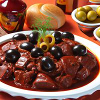 Cubed boneless flanken beef in a red sauce with olives
