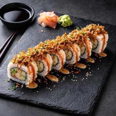 Rollos de sushi con cebolla frita y salsa